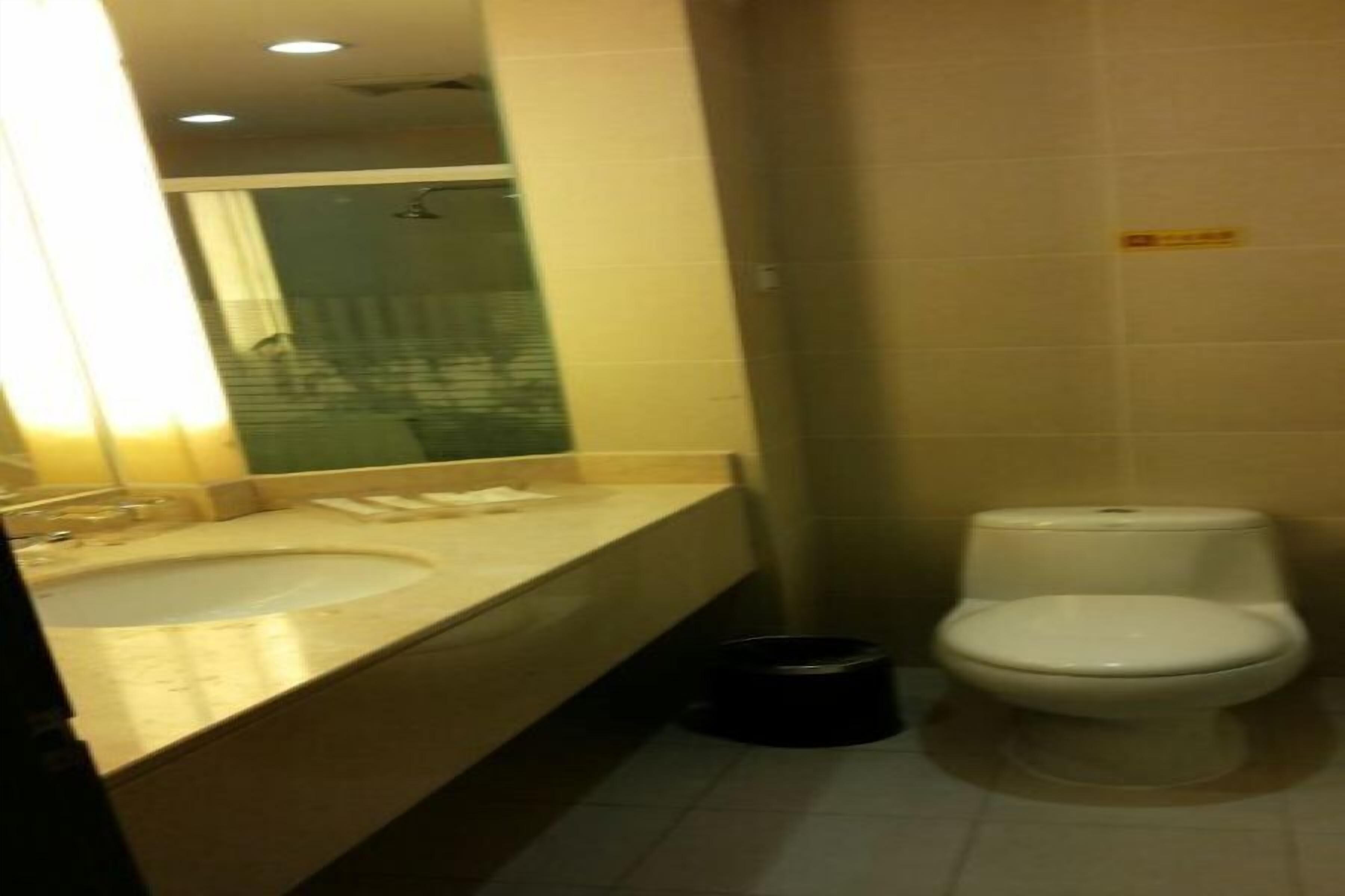 A small bathroom with a sink, mirror, and toilet.