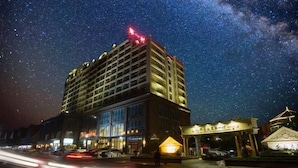 A hotel with a modern design, featuring a prominent entrance and multiple floors. - Diyicun Hot Spring Hotel (Dayi)