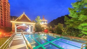 A rooftop pool area with glass panels, a gazebo, and a view of a mountain. - Diyicun Hot Spring Hotel (Dayi)