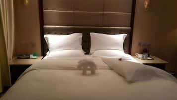 A hotel room with a large bed, two bedside tables, and a headboard with a padded design.