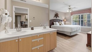 A bedroom with a double bed, a large mirror, a vanity with two sinks, and a ceiling fan. - 4 Bedroom, 4 Bathroom Walk-in Golf Condo near Branson Shopping & Entertainment (Branson)