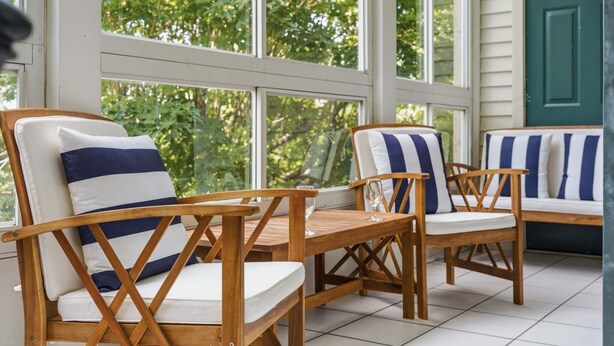 Two wooden chairs with white cushions and blue stripes, a wooden table, and a view through large windows to the outdoors. - 4 Bedroom, 4 Bathroom Walk-in Golf Condo near Branson Shopping & Entertainment (Branson)