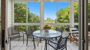 A covered patio with a round glass table, four chairs, and a ceiling fan. - 4 Bedroom, 4 Bathroom Walk-in Golf Condo near Branson Shopping & Entertainment (Branson)