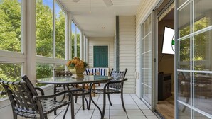 A covered patio with a glass table, metal chairs, a potted plant, and a door leading to an interior space. - 4 Bedroom, 4 Bathroom Walk-in Golf Condo near Branson Shopping & Entertainment (Branson)
