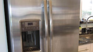 A stainless steel refrigerator with a water dispenser, double doors, and a freezer compartment. - Waterfront, Ground-Floor private residence with Ocean & Inlet views (Palm Beach Shores)