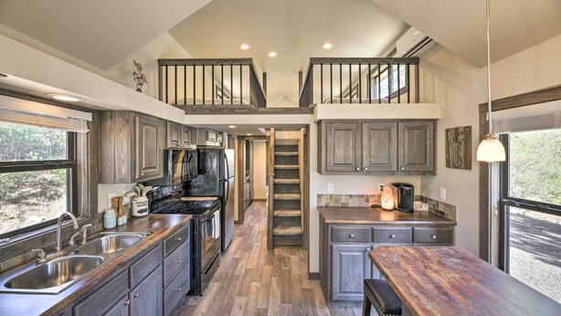 Une cuisine moderne avec des meubles en bois, des appareils électroménagers en acier inoxydable et un îlot central.