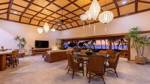A spacious dining area with a large table and chairs, a television, and a view of the ocean. - Ultra private oceanfront gated compound with pool & spa just minutes from town. (Kailua-Kona)