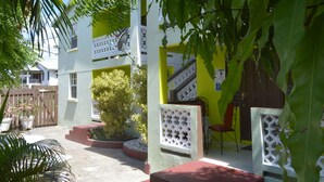 Un edificio de dos pisos con un balcón, una escalera y una puerta.
