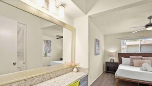 A bedroom with a bed, a nightstand, a lamp, a mirror, and a window with blinds. - Walk to Golf Course! Near Lake + Pool w Parking (Austin)