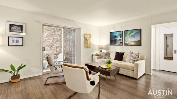 A modern living room with a stone wall, a sofa, a coffee table, and a chair. - Walk to Golf Course! Near Lake + Pool w Parking (Austin)