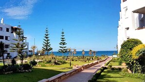 A pathway leading to a building with a view of the sea.