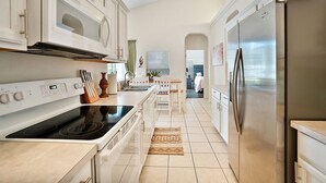 A modern kitchen with white cabinetry, stainless steel appliances, and a central island. - *Disney Pool Home-Heated Pool Included-Clermont FL (Clermont)