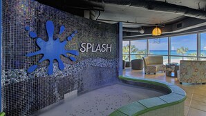 Ein Wellnessbereich mit Mosaikwand, Pool und Blick auf den Strand.