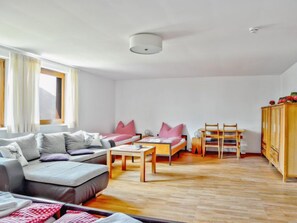 A modern living room with a sofa, a coffee table, a small table, and a wooden cabinet. - Runnimoos by Interhome (Laterns)