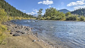 Une rivière aux eaux claires, bordée d’un paysage rocheux et d’une forêt dense.