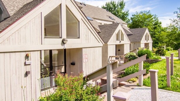 A row of wooden cabins with a covered walkway connecting them. - Whiffletree D3 (Killington)