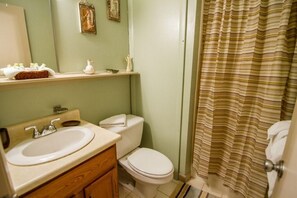 Ein Badezimmer mit Waschbecken, Toilette und Duschvorhang.