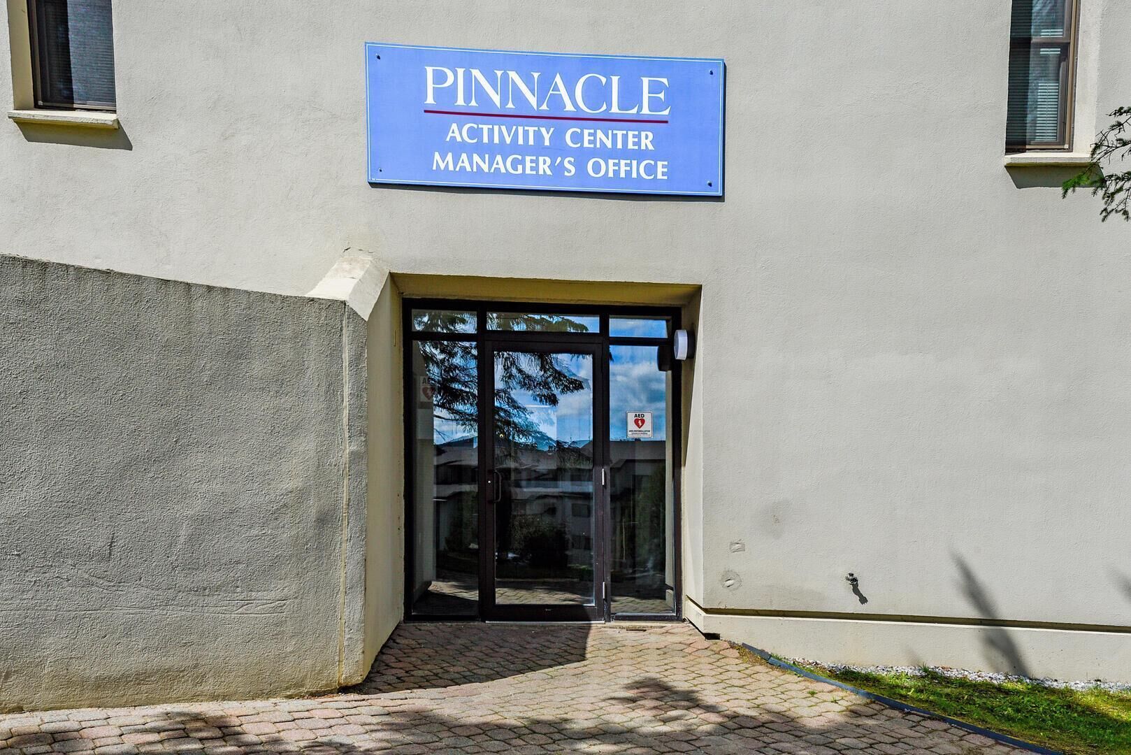 The exterior of a building with a sign reading "Pinnacle Activity Center Manager's Office."