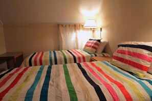 A hotel room with two beds, striped bedding, a nightstand, and a lamp. - Whiffletree B8 (Killington)
