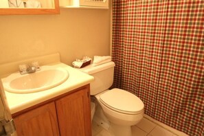 A bathroom with a sink, toilet, and a checkered shower curtain. - Whiffletree B8 (Killington)