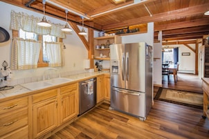 Una cocina con armarios de madera, un refrigerador de acero inoxidable y un lavavajillas empotrado.