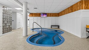 A swimming pool with a unique design, a bench, and a television screen on the wall. - Pinnacle E08 (Killington)