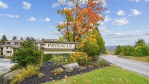 A sign for Pinnacle with directional arrows to amenities like A, B, C, D, E, F, and SPA. - Pinnacle E08 (Killington)