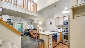 A modern apartment with a kitchen, dining area, and living room. - Woods Village 37 (Killington)