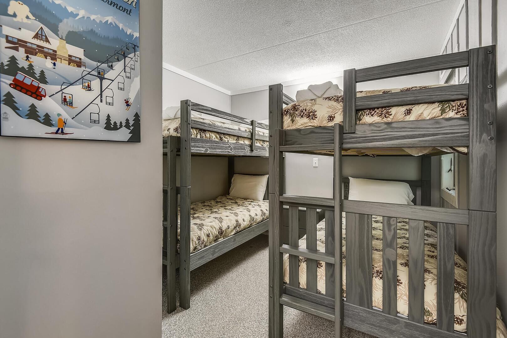 A room with bunk beds, a ski slope illustration, and a window.
