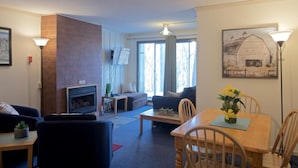 Un salon avec une cheminée, un canapé et une table à manger.