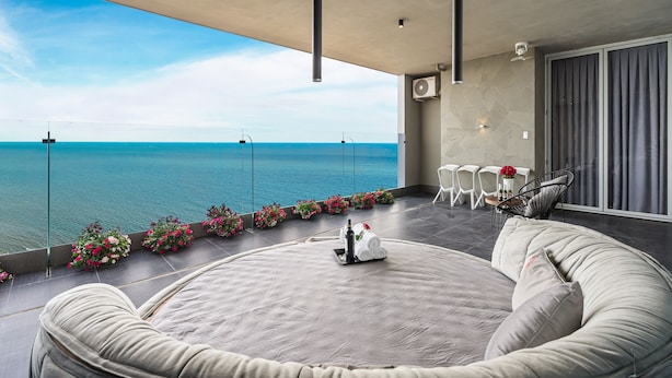 A modern outdoor seating area with a view of the sea, a round table with chairs, and a sofa. - Stephen Luxury Apartments (Ho Chi Minh City)