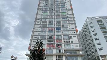 A tall residential building with multiple balconies and a ground-level entrance.