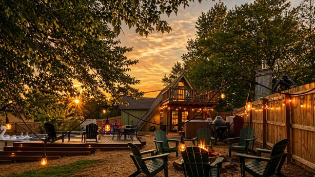 A backyard with outdoor seating, a barbecue area, and a wooden deck.