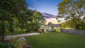 A house with a green lawn, a wooden deck, and a wooden fence.