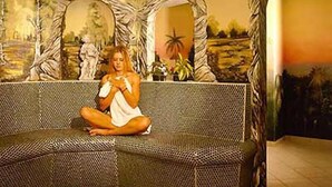 A room with a patterned sofa, a large mirror, and a painting of a landscape. - Ferienhotel Hoppet (Hart im Zillertal)