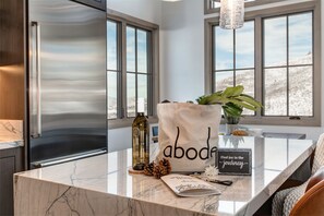 Enjoy a homey atmosphere in this kitchen with a large refrigerator, marble countertop, and a view of the surrounding landscape.