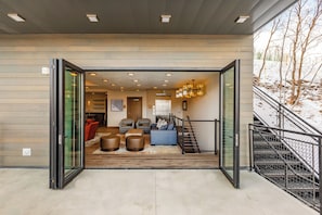 Relax in a comfortable space with seating areas and a staircase leading to an upper level.