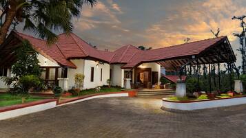 Traditional architecture meets serene surroundings in this charming property, set amidst lush gardens and palm trees.