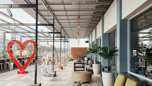 A spacious indoor area with a high ceiling, modern furniture, and large windows. - Paradise by CaLia Tarakan (Tarakan)