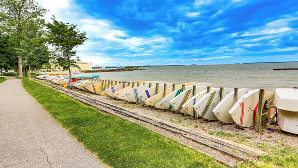 A row of boats lined up along a grassy area next to a body of water. - Walk to Lake: Historic Lakeside Marblehead Cottage (Lakeside Marblehead)
