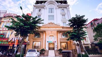 A grand building with a sign reading "THAI HA LUXURY HOTEL".