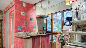 Een keuken met rode muren, een raam met uitzicht en een gootsteen.