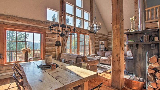 A rustic cabin interior with a large dining table, wooden walls, and a fireplace. - ‘Snow Pine Retreat’ - Remote Crescent Log Cabin! (Crescent)