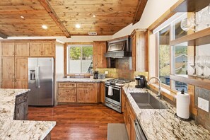 Una cocina con armarios de madera, un refrigerador de acero inoxidable, una estufa y un lavaplatos.