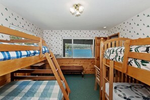 Ein Zimmer mit Etagenbetten, einem Fenster mit Blick und einer Deckenleuchte.