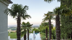 Ein Poolbereich mit Liegestühlen und Blick auf die Landschaft.