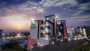 Un hôtel moderne à plusieurs étages, doté de balcons et d’une enseigne bien visible indiquant qu’il s’agit d’un complexe hôtelier.