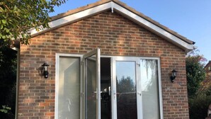 A brick house with a gabled roof and two sliding glass doors. - Nice 2 Bed Independent Annex in High Wycombe (High Wycombe)