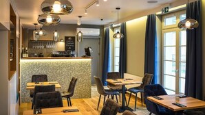 A modern restaurant with a bar area, wooden tables, and dark curtains. - Villa Bałtycka (Gdansk)