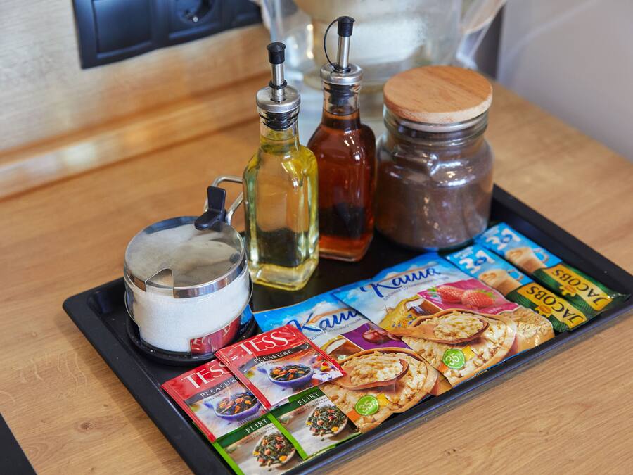 Uma bandeja com acompanhamentos, uma revista e um pote de biscoitos.